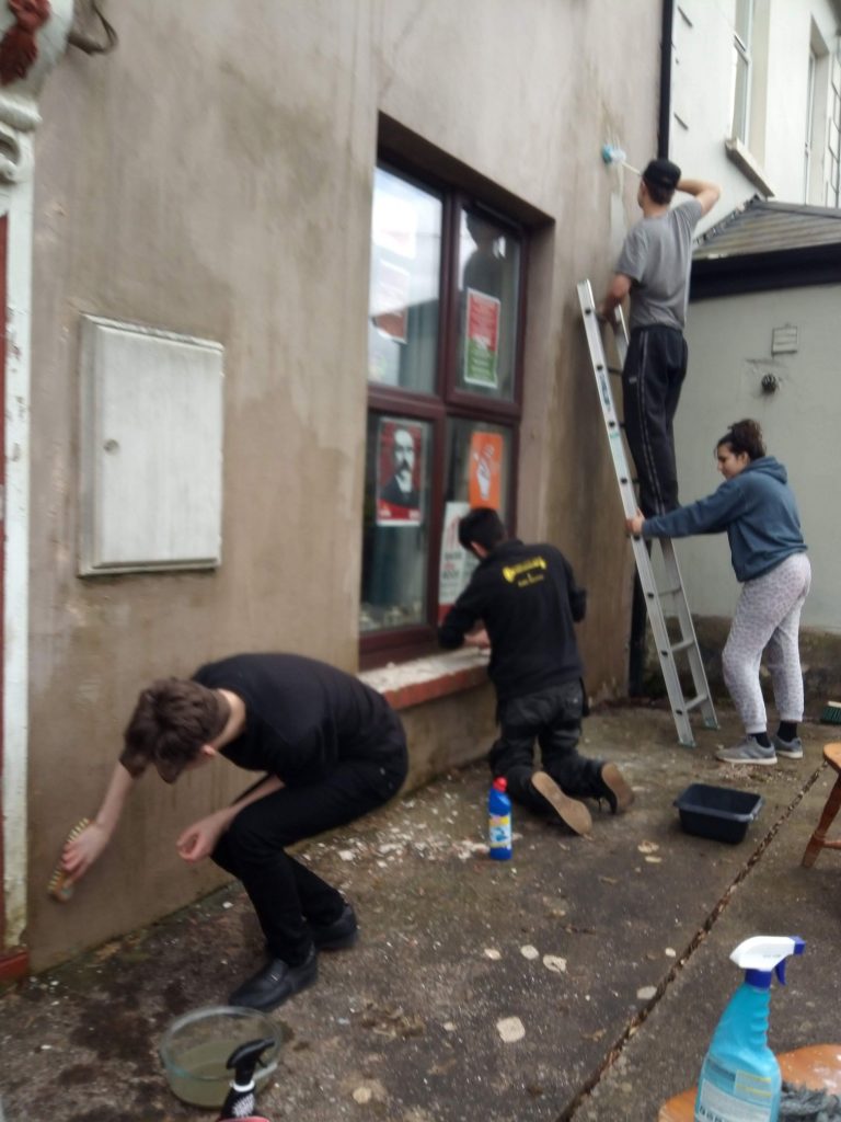 Members of the CYM cleaning the front of Connolly Barracks, preparing for a repaint