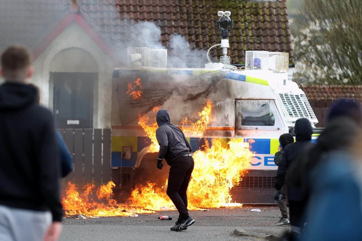A youth throws a petrol bomb at a PSNI Land Rover